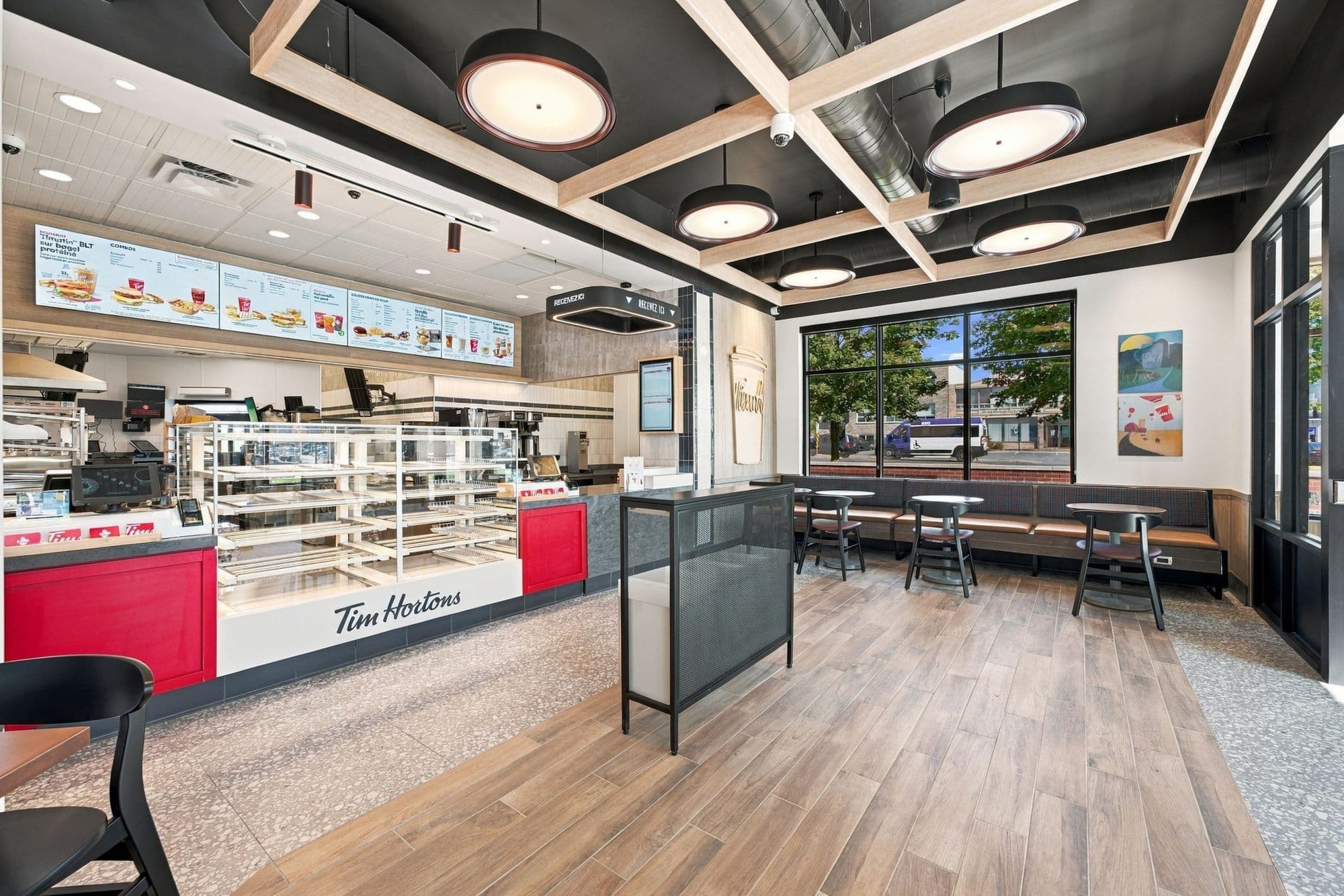Intérieur du Tim Hortons de Châteauguay : comptoir de commande, vitrine de beignes et salle à manger