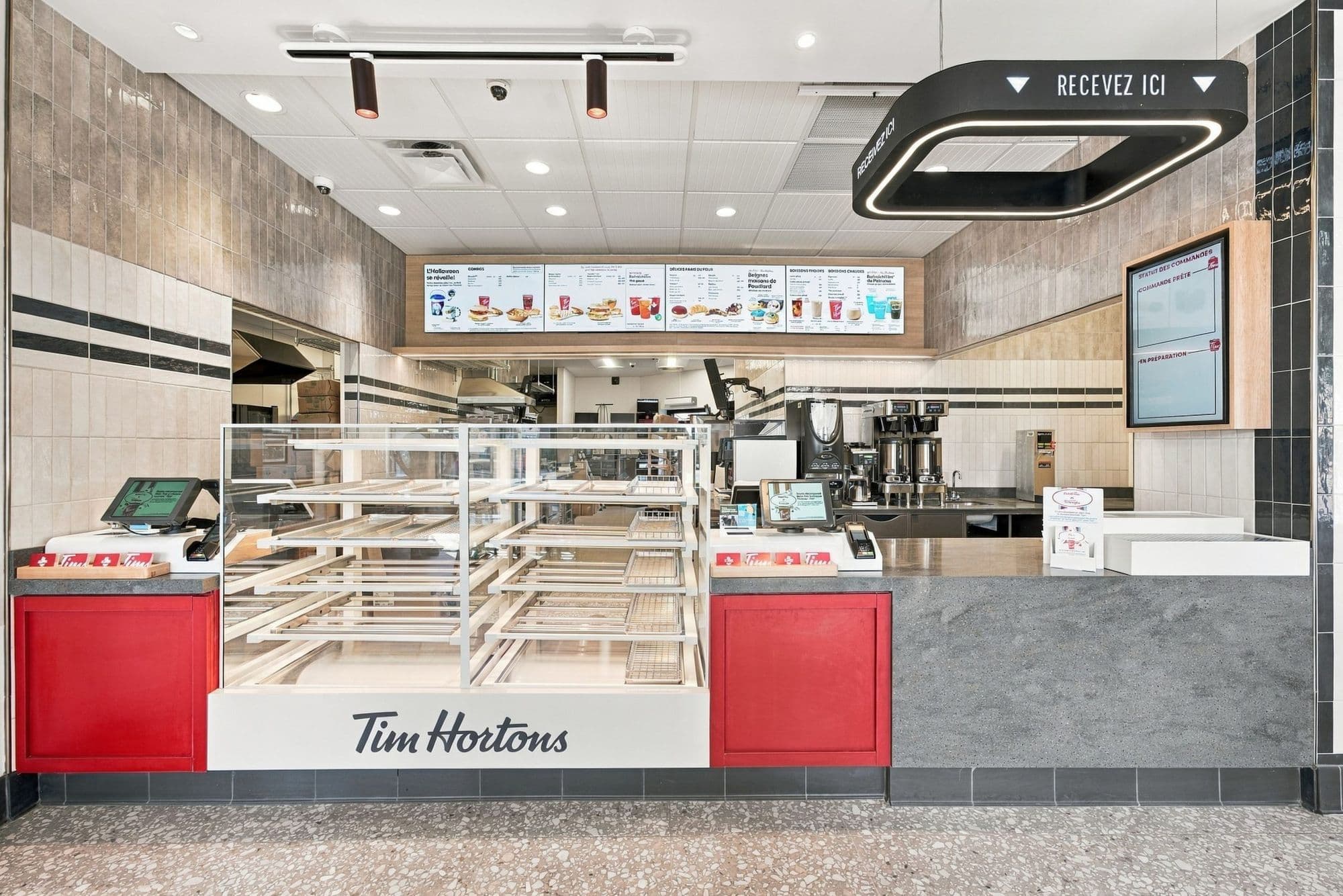 Comptoir de service avec vitrine de beignes et écrans de menu numériques