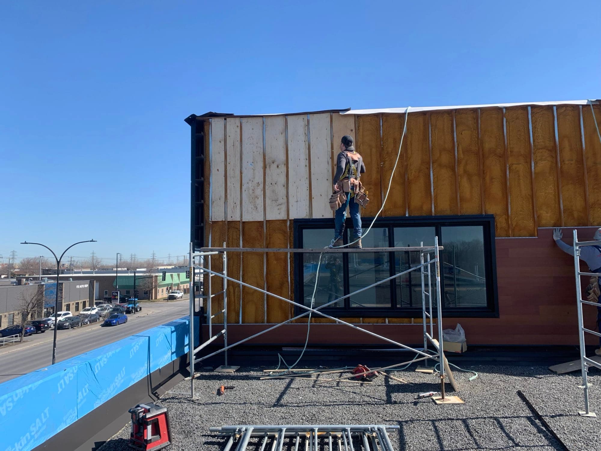 Travailleur sur un échafaudage devant une façade en rénovation