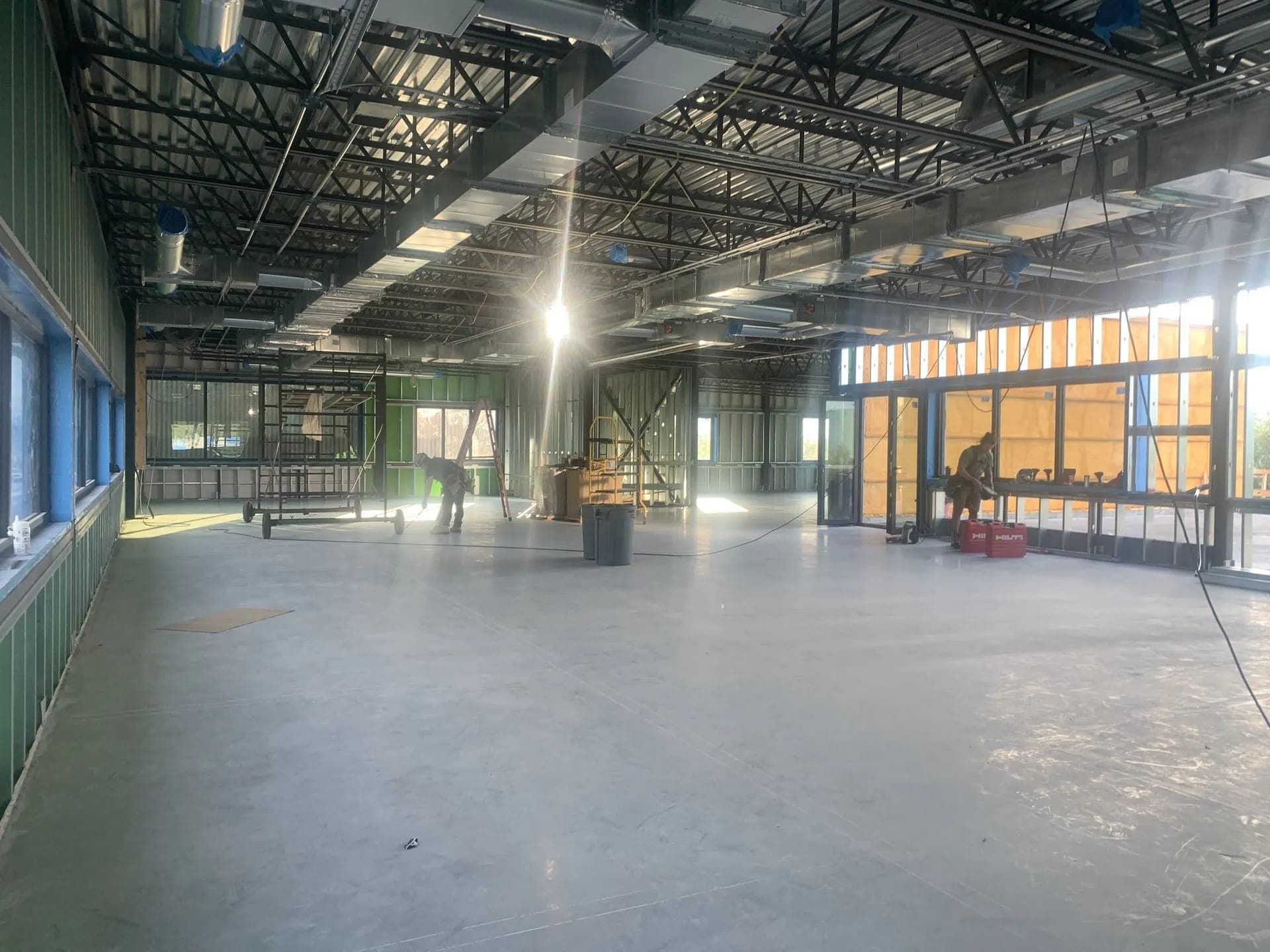 Intérieur d’un bâtiment en chantier, grandes fenêtres et dalle de béton