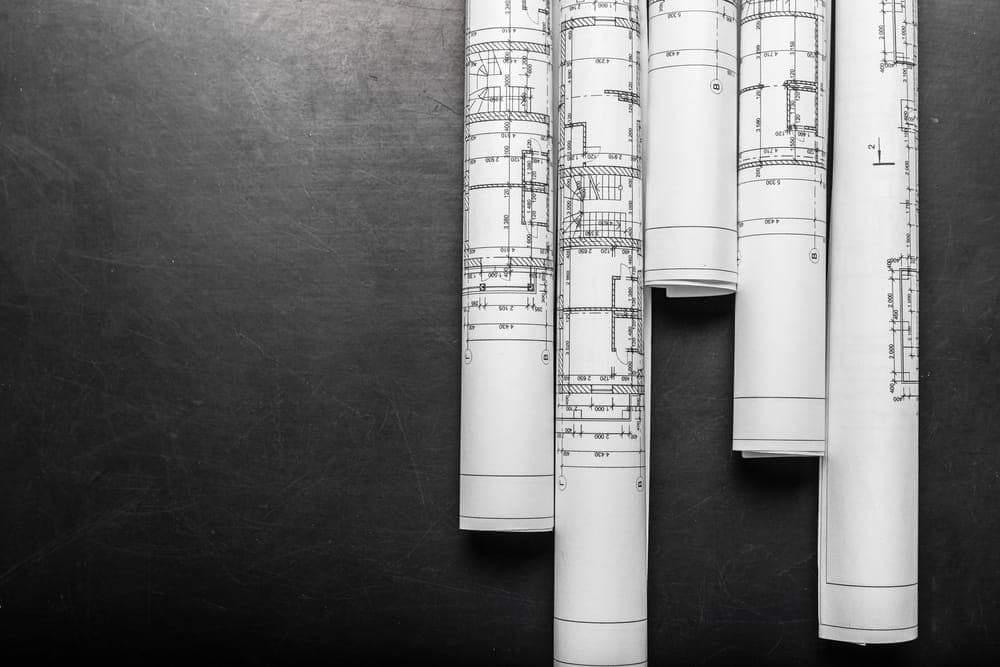 Plans de construction roulés sur un fond foncé