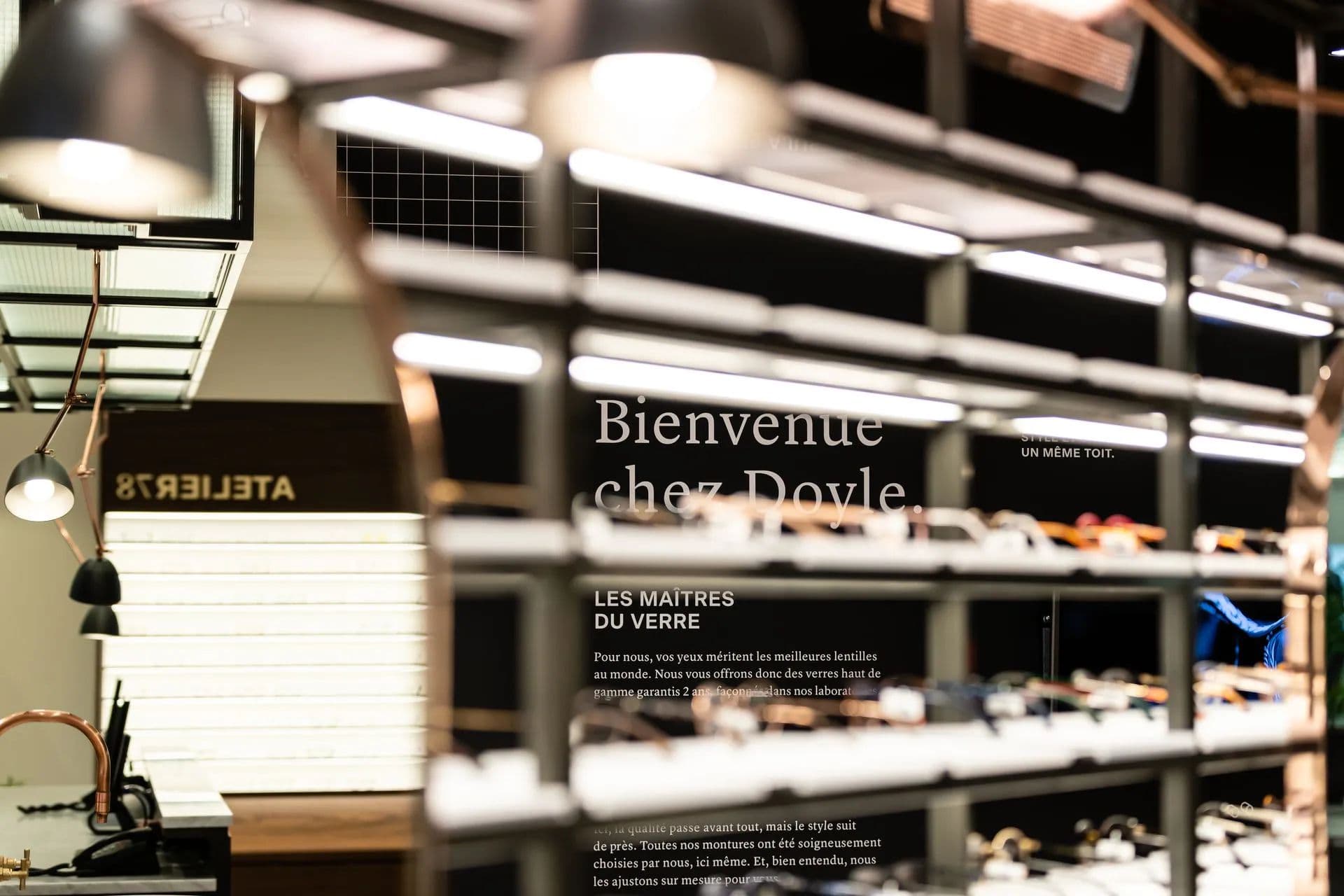 Présentoirs de montures en gros plan, avec l’inscription « Bienvenue chez Doyle » en arrière-plan
