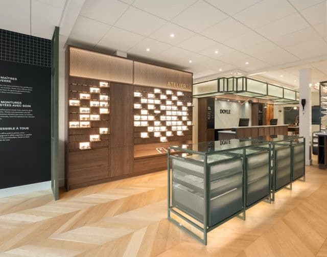 Mur de présentation des montures en bois et vitrine-comptoir en acier et verre