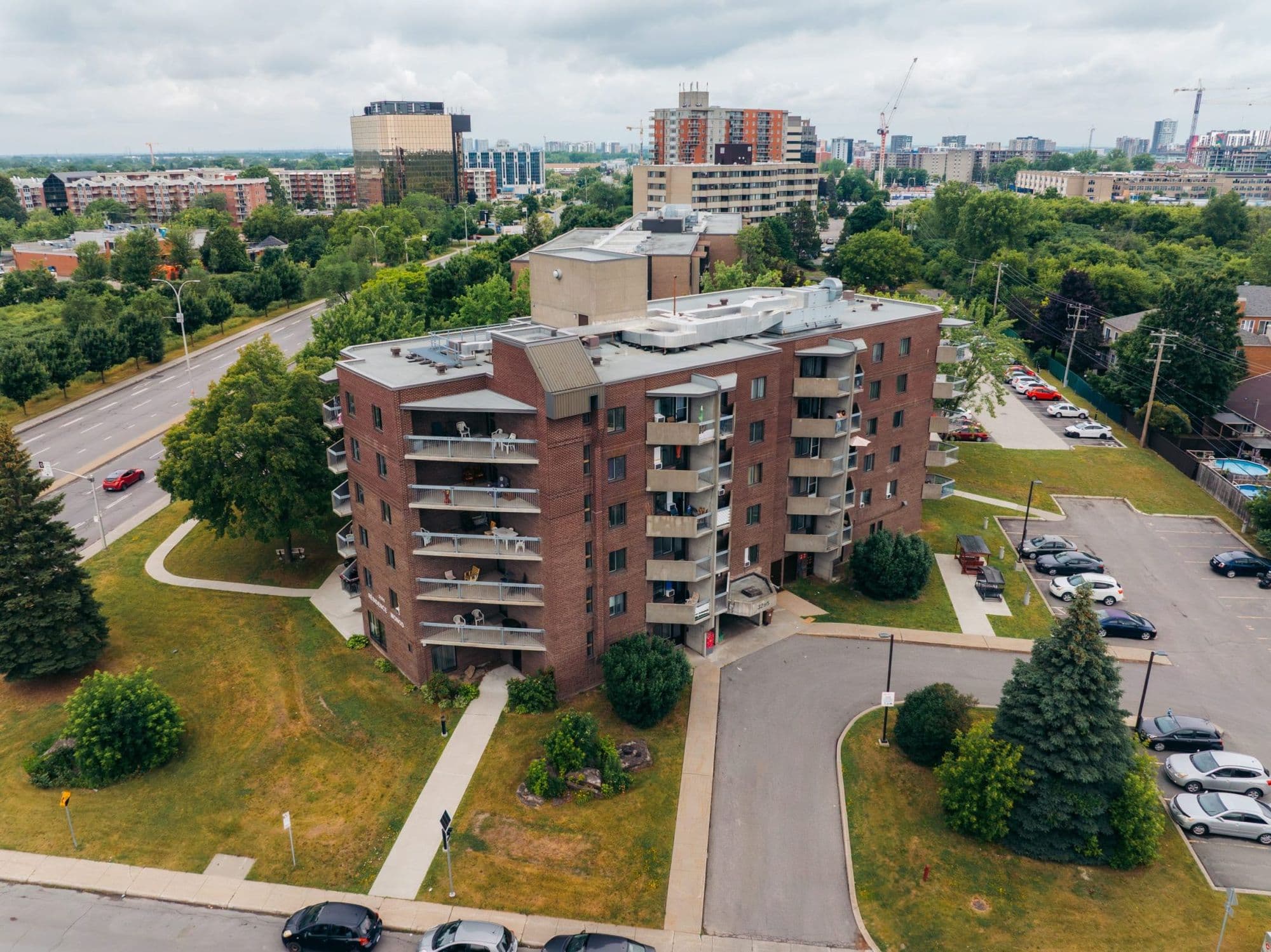 Vue aérienne de l’immeuble en brique des Habitations Monod à Laval, entouré de pelouses et d’un stationnement
