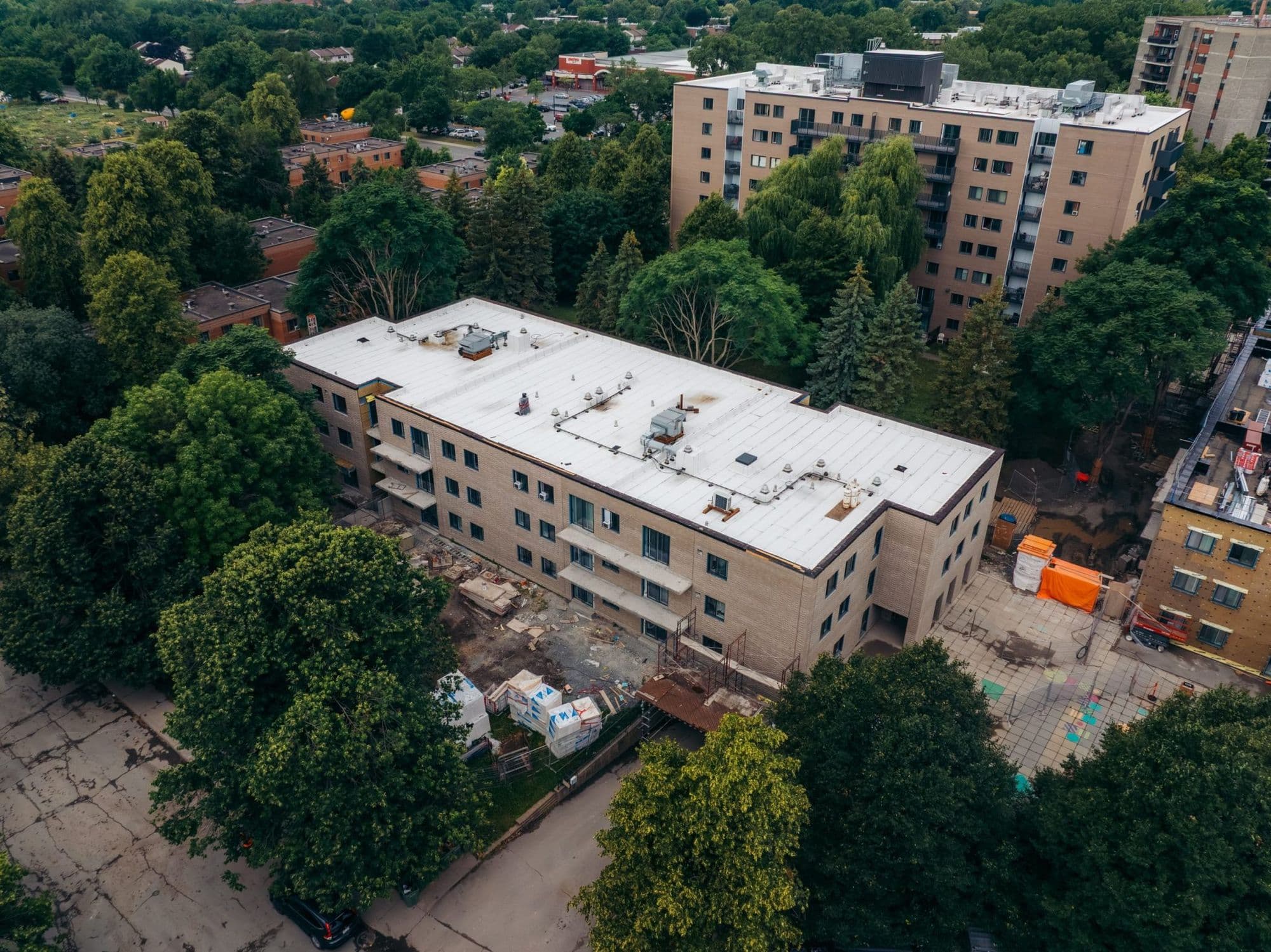 Vue aérienne d’un immeuble résidentiel de trois étages des Habitations André-Grasset pendant les travaux