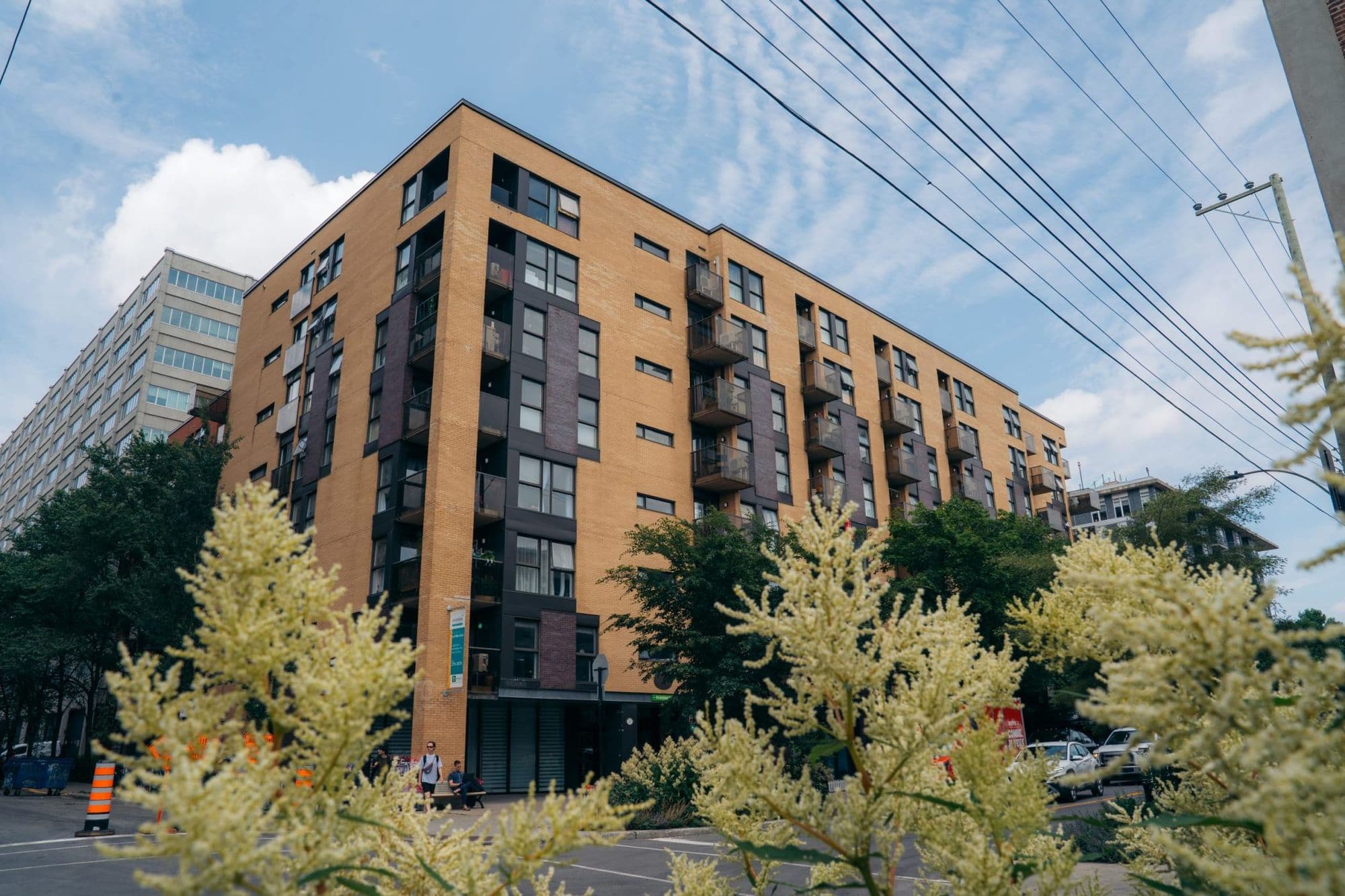 Immeuble résidentiel de neuf étages en brique, vu en contre-plongée depuis la rue